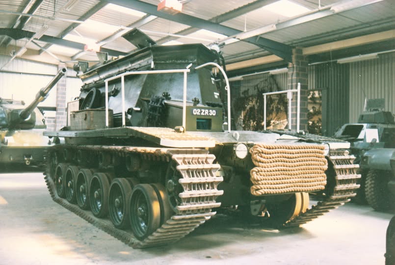 Military vehicles and equipment gathered in the yard of the Budge collection.