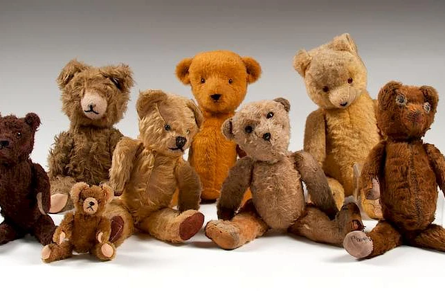 Hero image direction: a small group showing the breadth of serious teddy-bear collecting - one early mohair bear with visible wear, one exceptionally preserved historic bear and one distinctive artist bear. Avoid a generic nursery or toy-shop image.