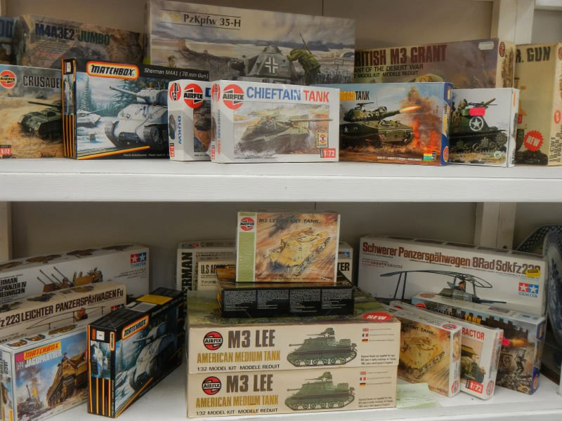 A collection of vintage and modern model kits with illustrated boxes and unbuilt parts.